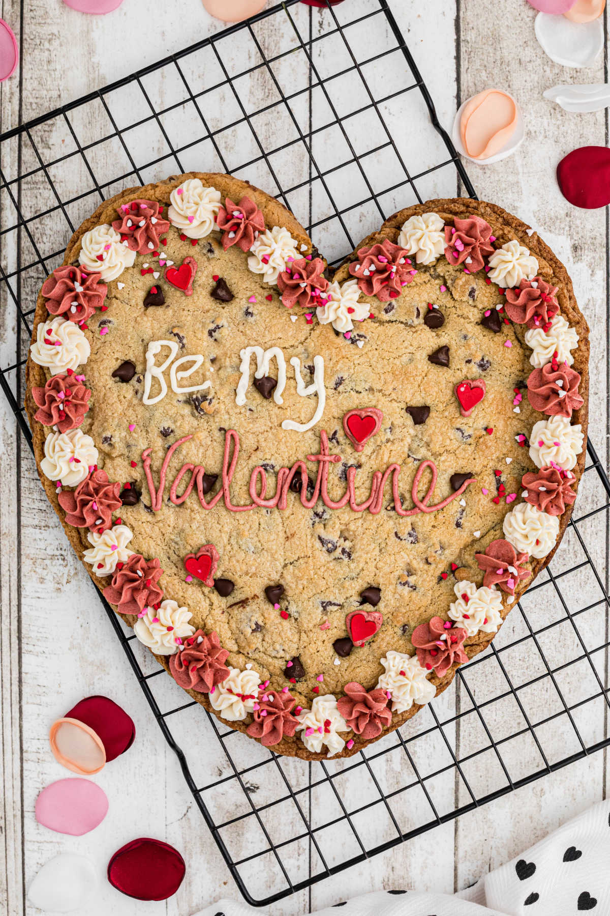 An overhead shot of a giant valentines cookie on a cooling rack.