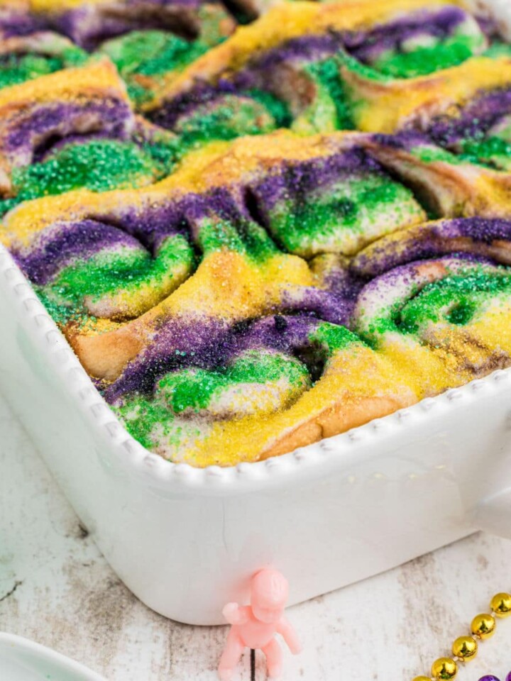 A dish full of king cake cinnamon rolls cropped square.