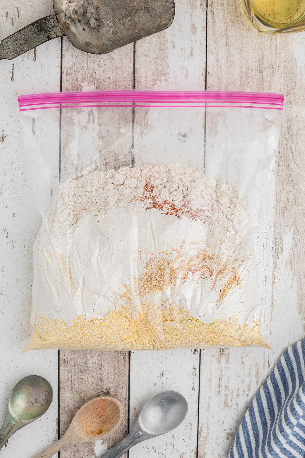 A resealable bag with flour and seasonings.