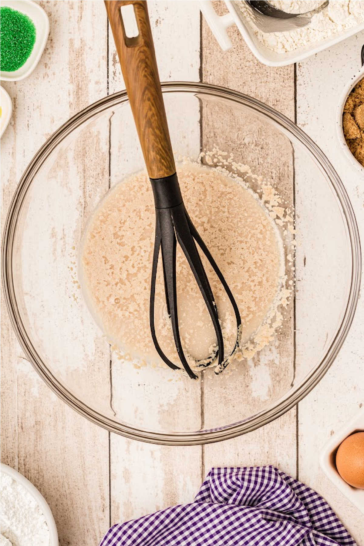 Yeast, water and sugar in a bowl with a whisk.