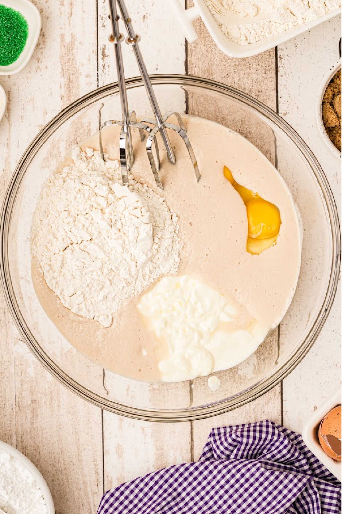 A mixture of flour and eggs in a bowl with a whisk.