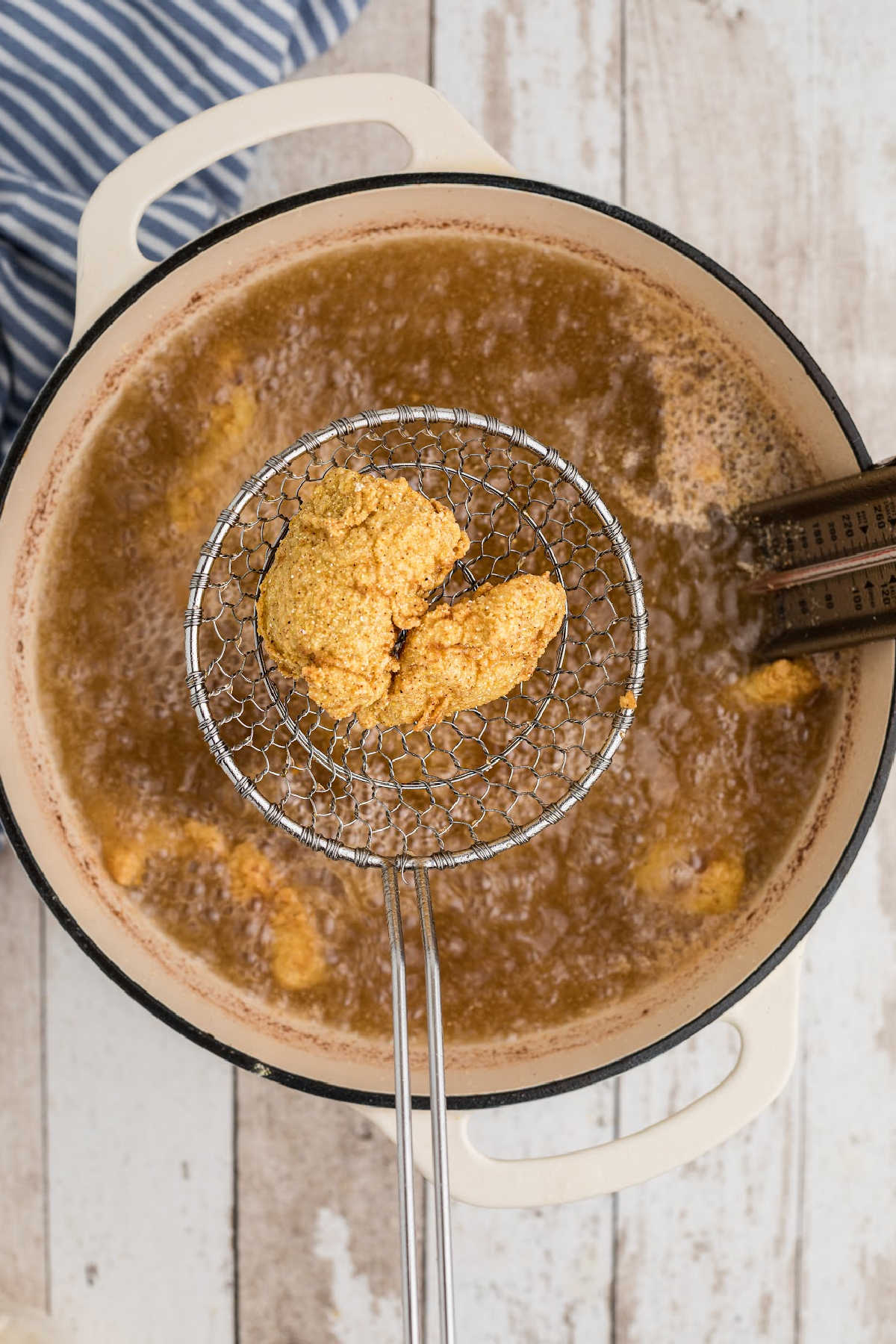 A pot full of grease, frying some catfish fillets.