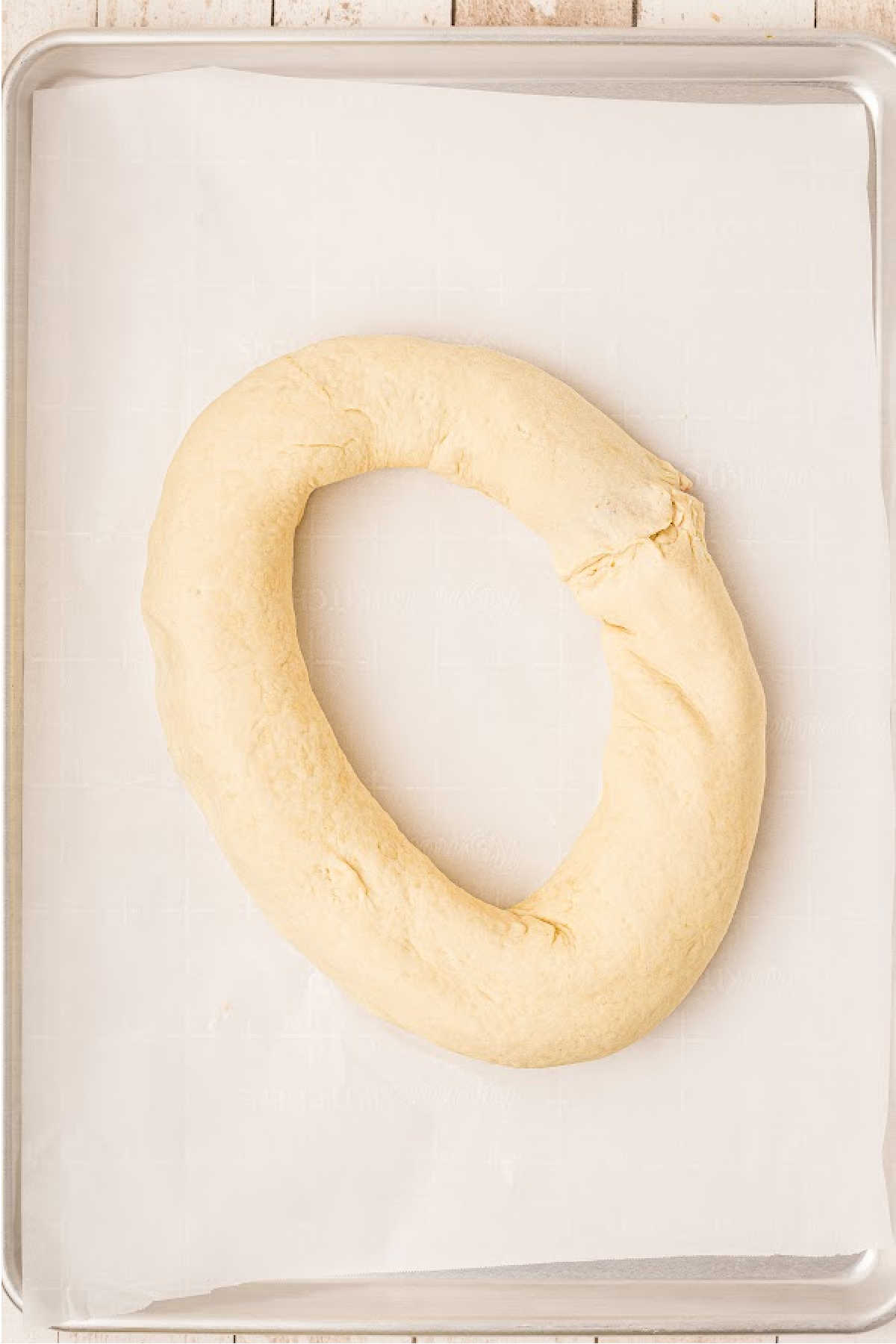 A ring of dough on parchment paper.