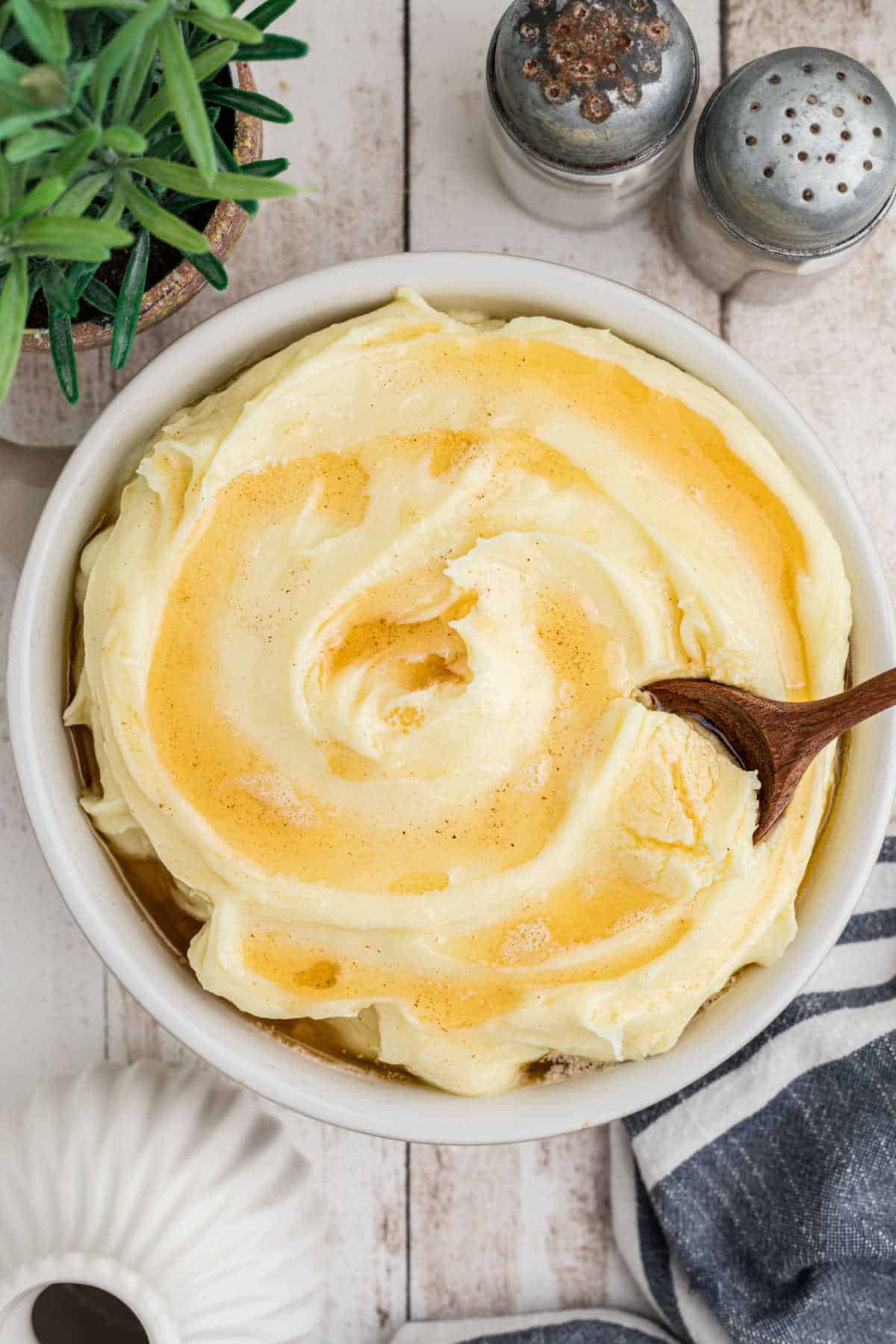 Overhead view of a bowl of amish mashed potatoes with a spoon digging in.