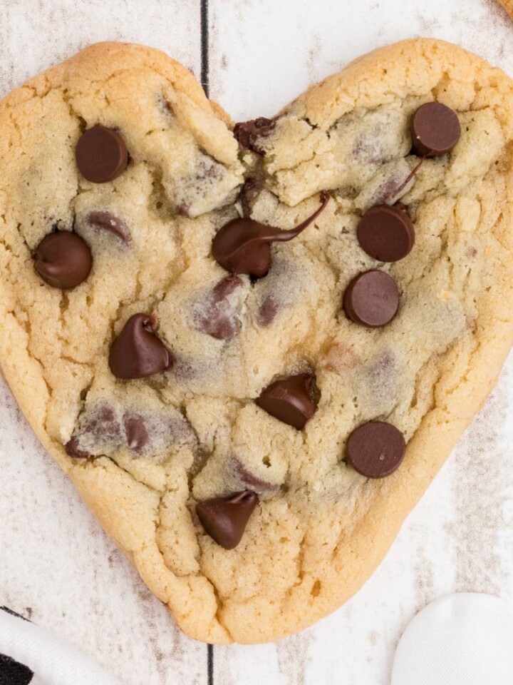 Overhead picture of heart shaped chocolate chip cookies, cropped square.
