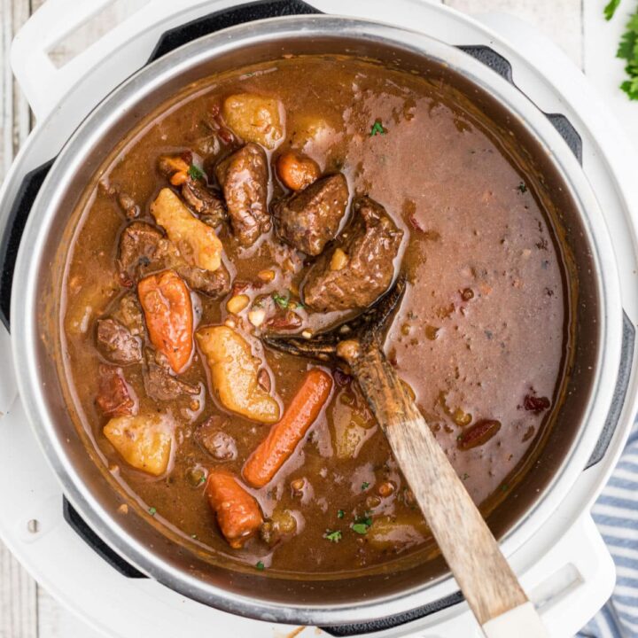 An instant pot venison stew with a spoon digging in.