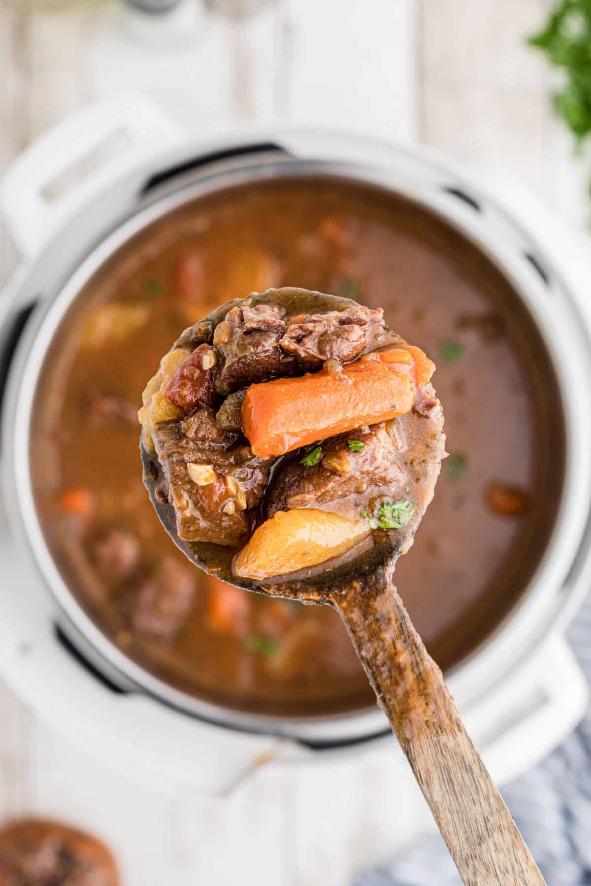 Instant Pot Venison Stew on a spoon over the pot.