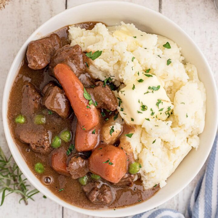 Overhead shot of a bowl full of Irish Stew with Mashed Potatoes, cropped square.
