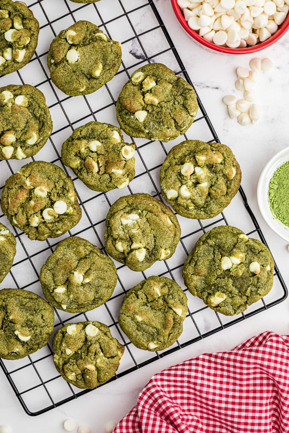 An overhead picture of a cooling rack with matcha cookies spread out.