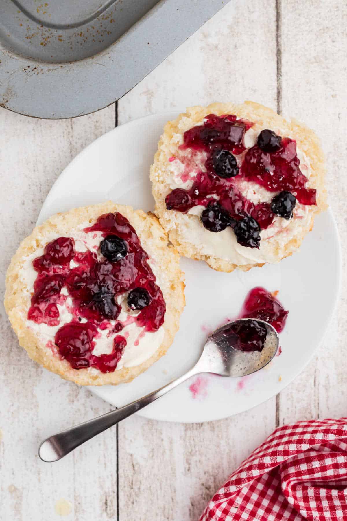 Old fashioned southern biscuits cut in half with jam spread on top.