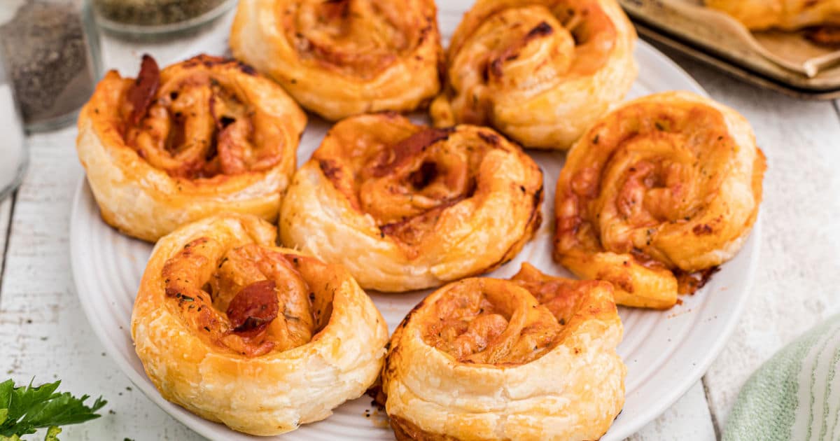 Close up of a plate full of puff pastry pizza pinwheels.