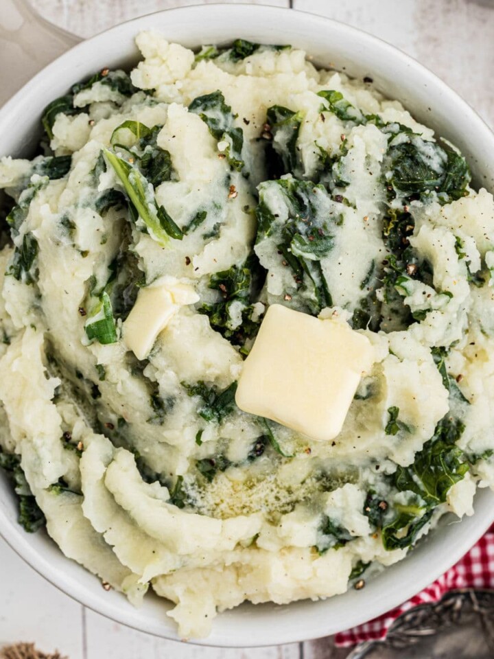 Overhead shot of a bowl of traditional colcannon with a butter slice melting on top.