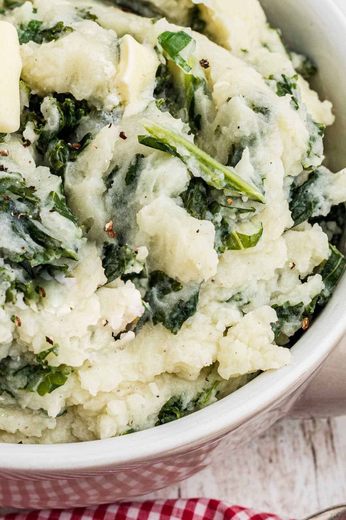 Very close up shot of a bowl of traditional colcannon, with kale.