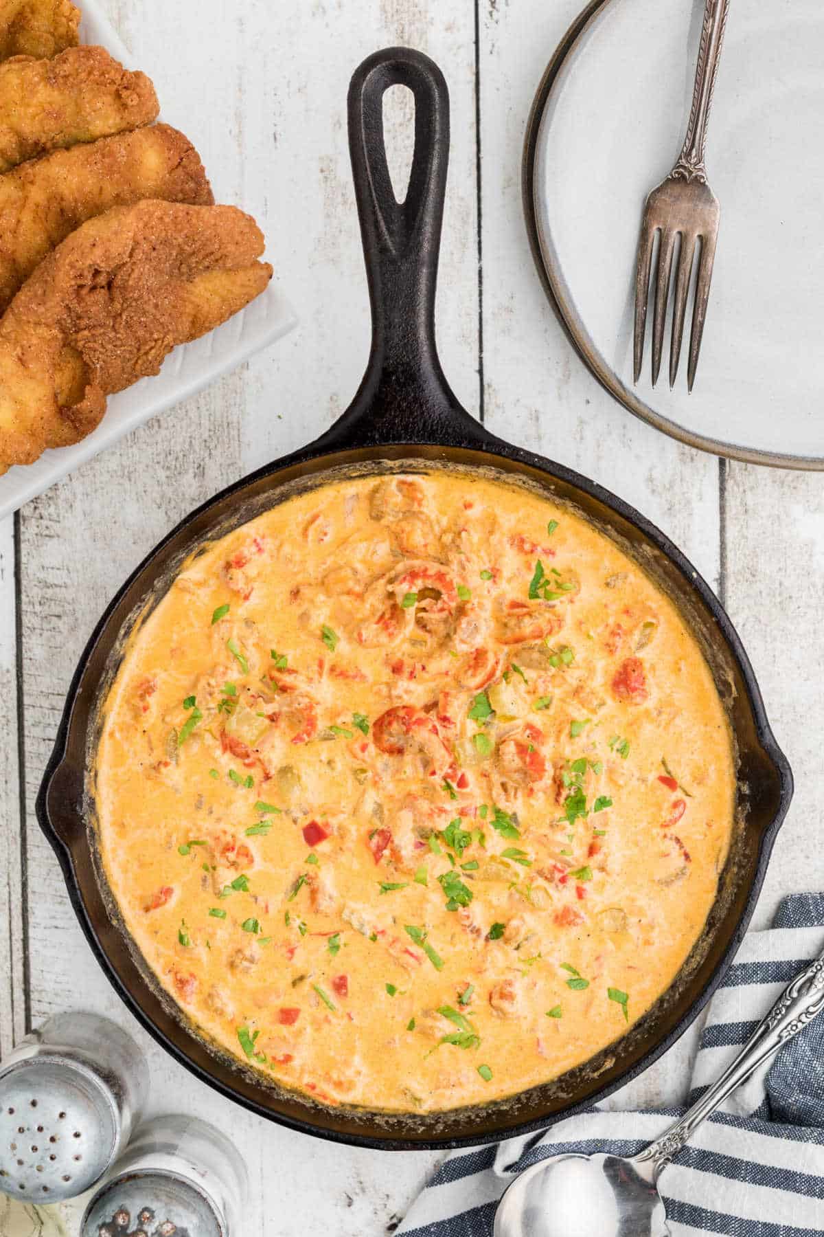 Overhead view of a crawfish sauce in a cast iron skillet.