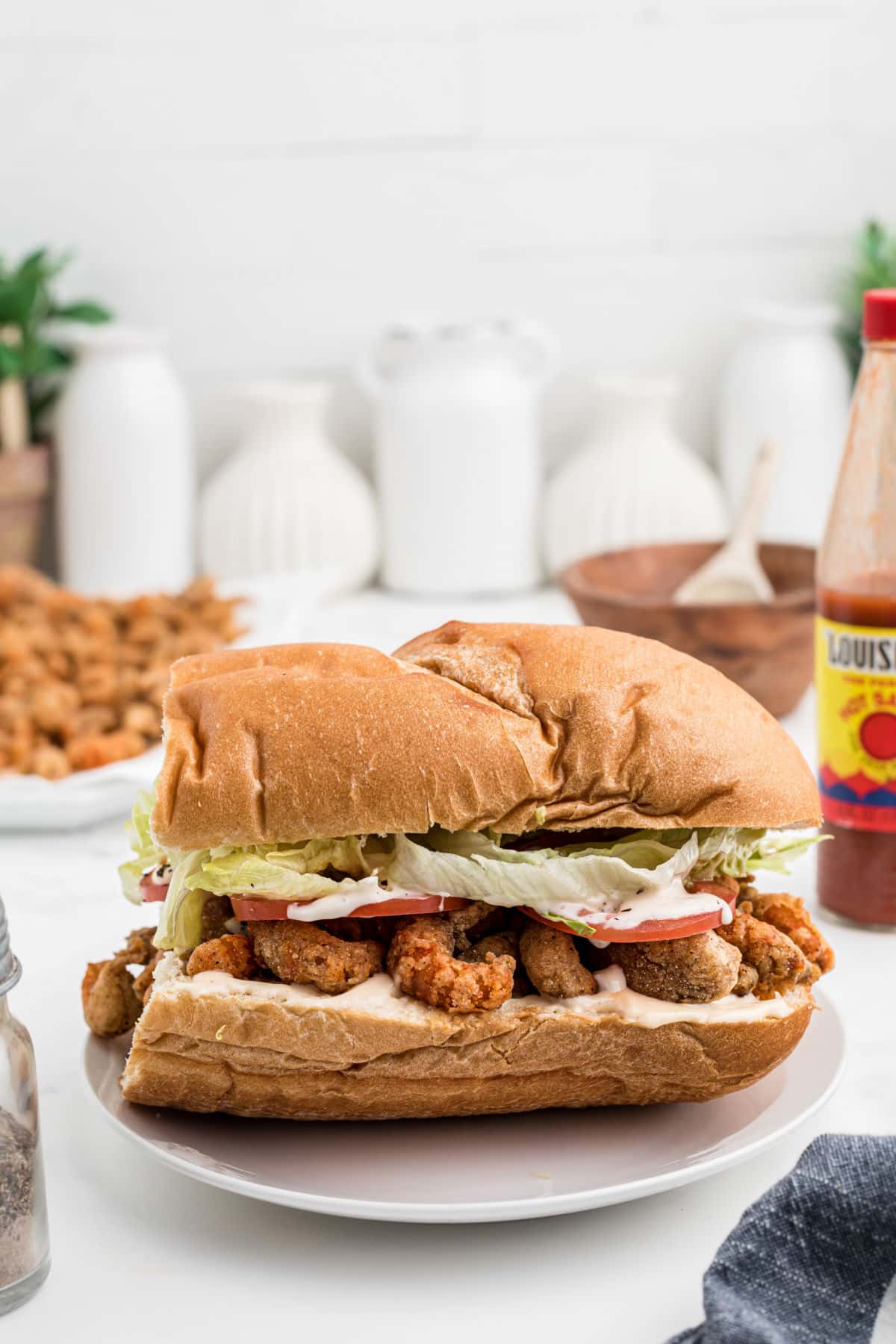 Side view of a closed dressed fried crawfish poboy.