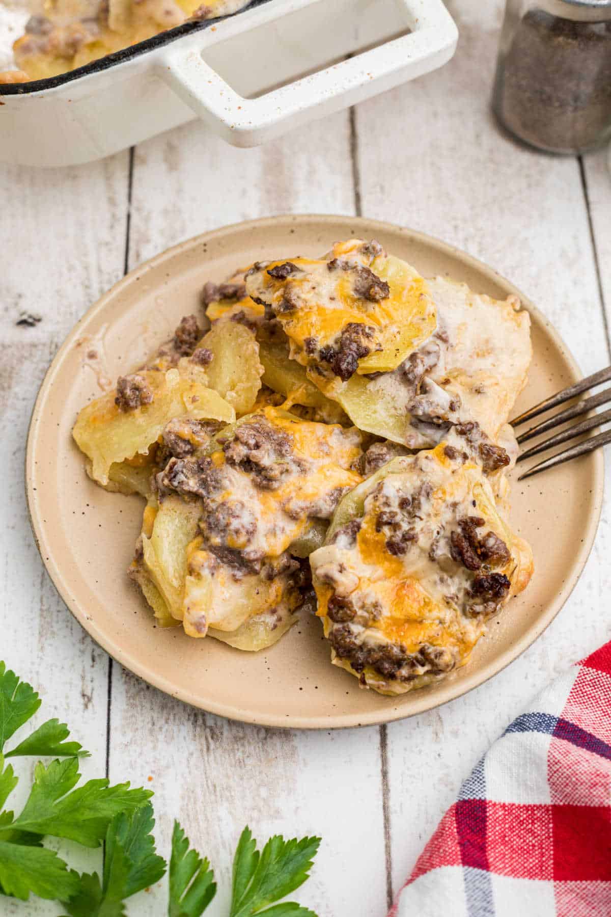 A plate of hamburger potato casserole with a fork nearby, looks like it's digging in.