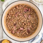 Overhead view of a pot of pinto beans with text overlay for pinterest.