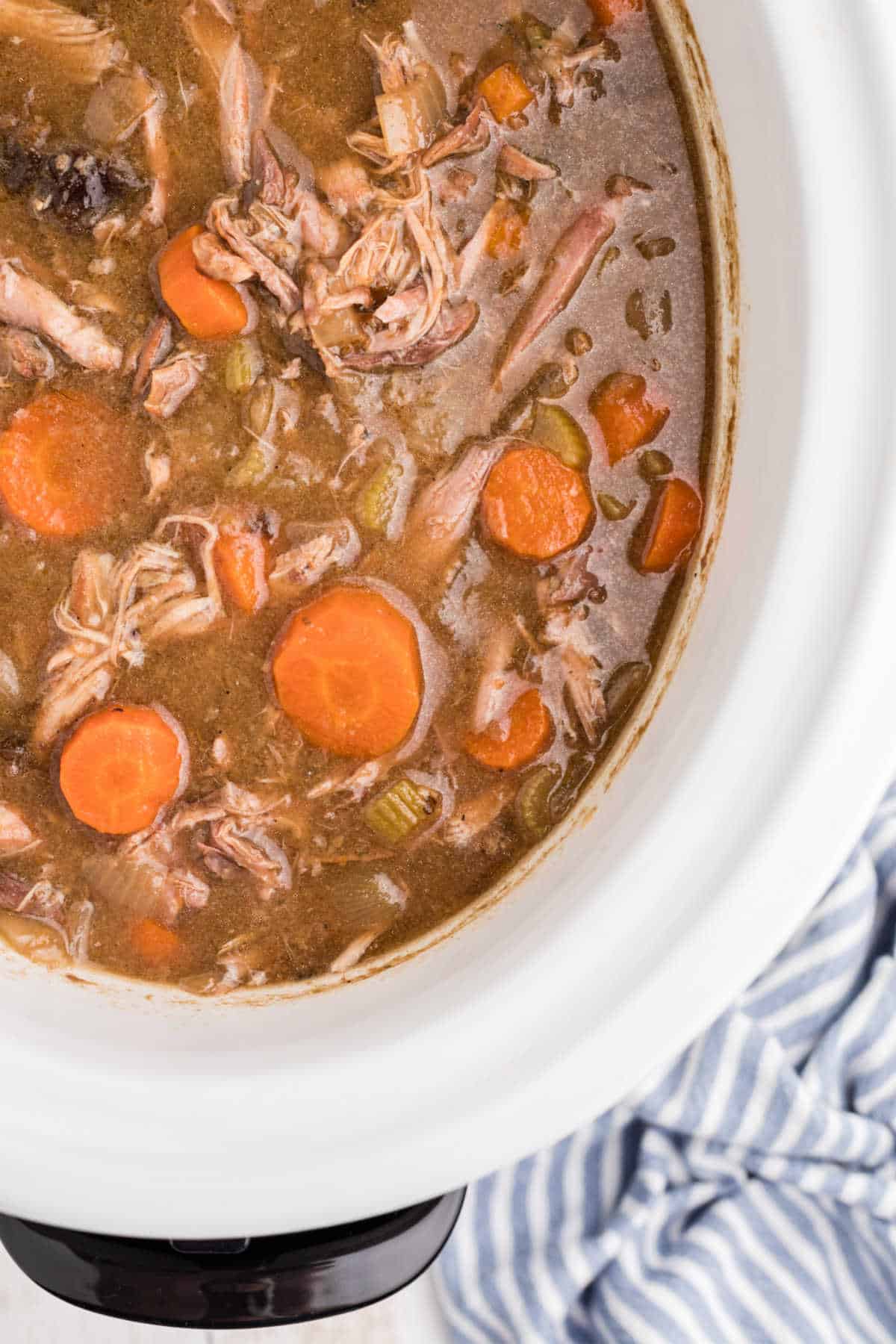 Overhead close up of slow cooker rabbit stew with carrots.
