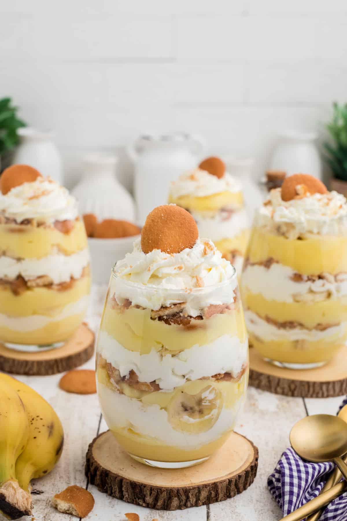 A tall image of some banana pudding cups in glasses.