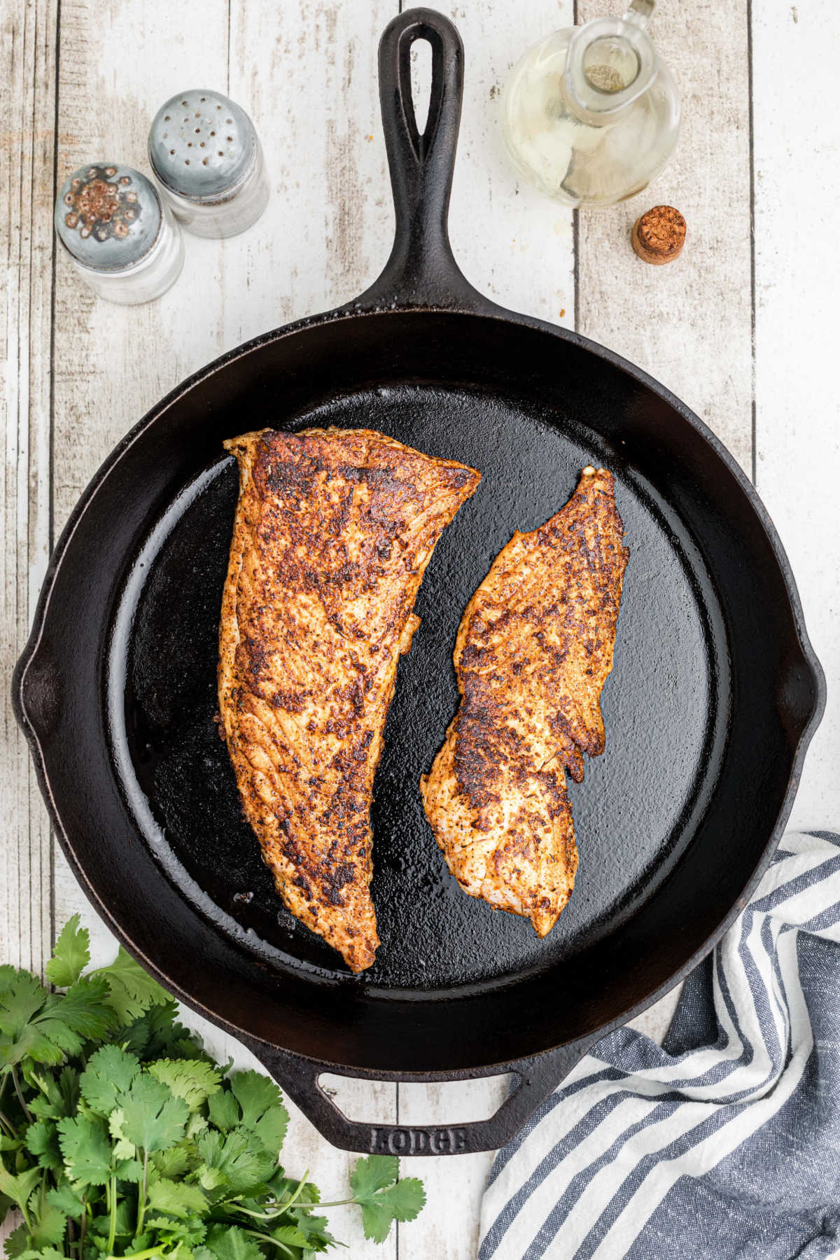 Overhead shot of blackened redfish in a skillet.