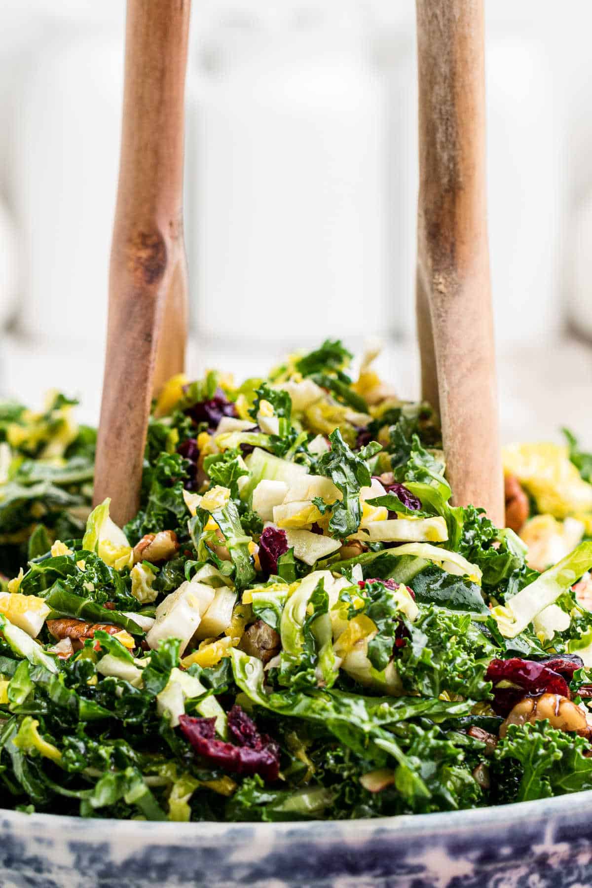 Close up of a cracker barrel kale salad with a fork and spoon digging in.