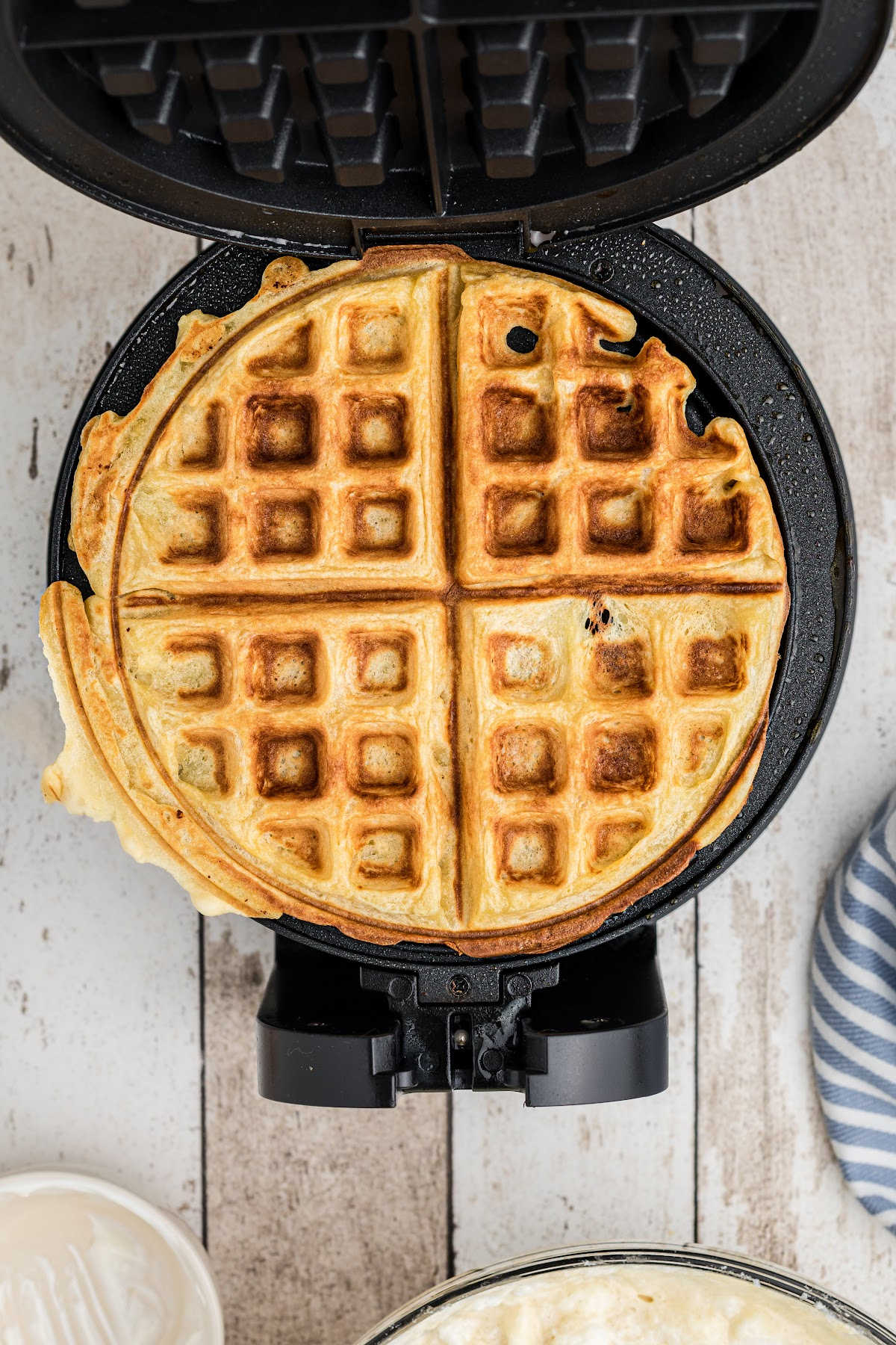 A cooked waffle on a waffle iron.