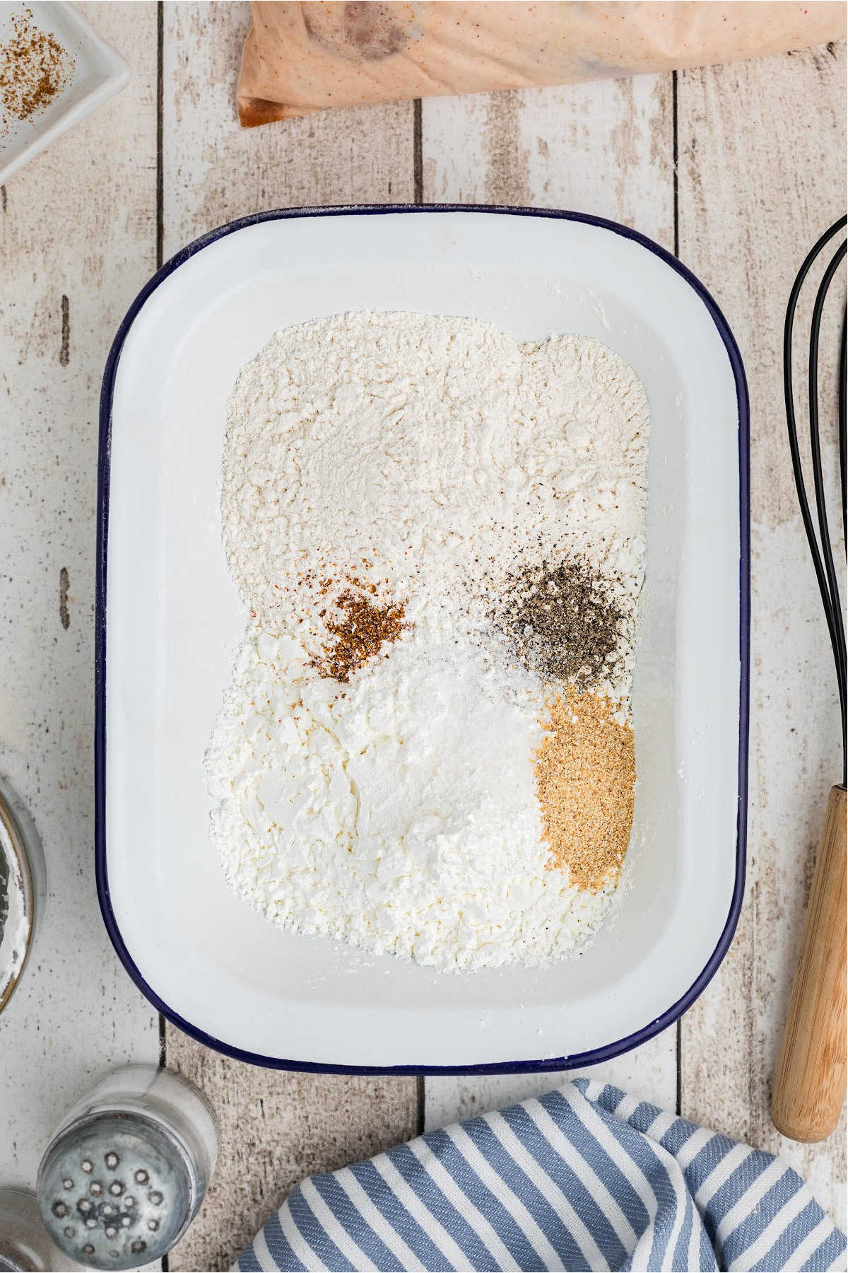 A mixing dish filled with flour and seasonings.