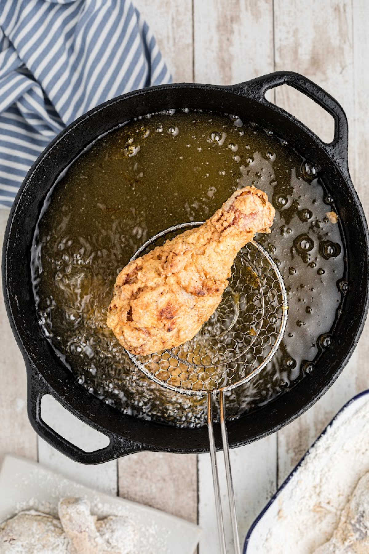Chicken frying in a black pot.
