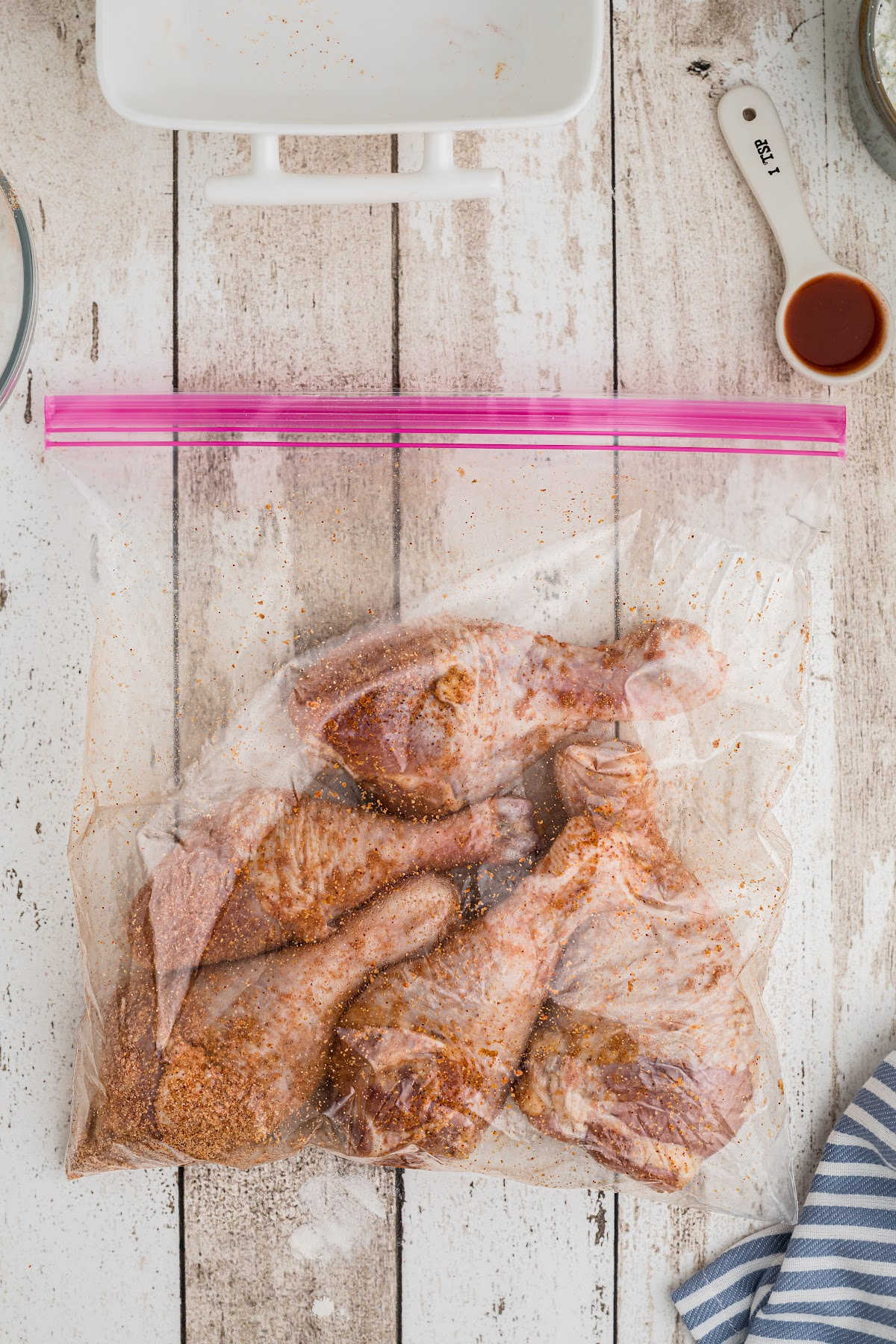 Seasoned chicken legs in a resealable bag.