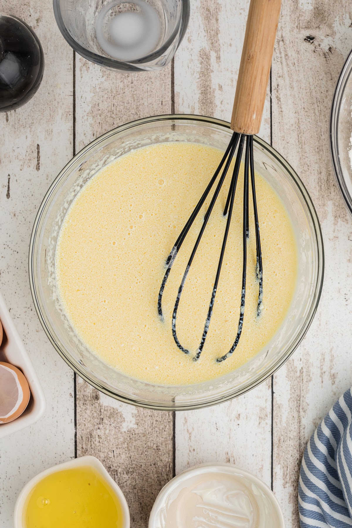 A large mixing bowl with a butter, egg and vanilla mixture.