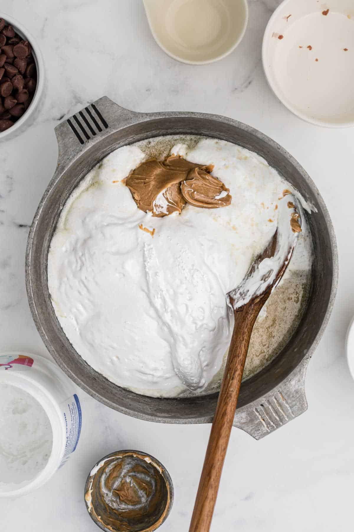 Marshmallow fluff added to a pot with melted butter and sugar.