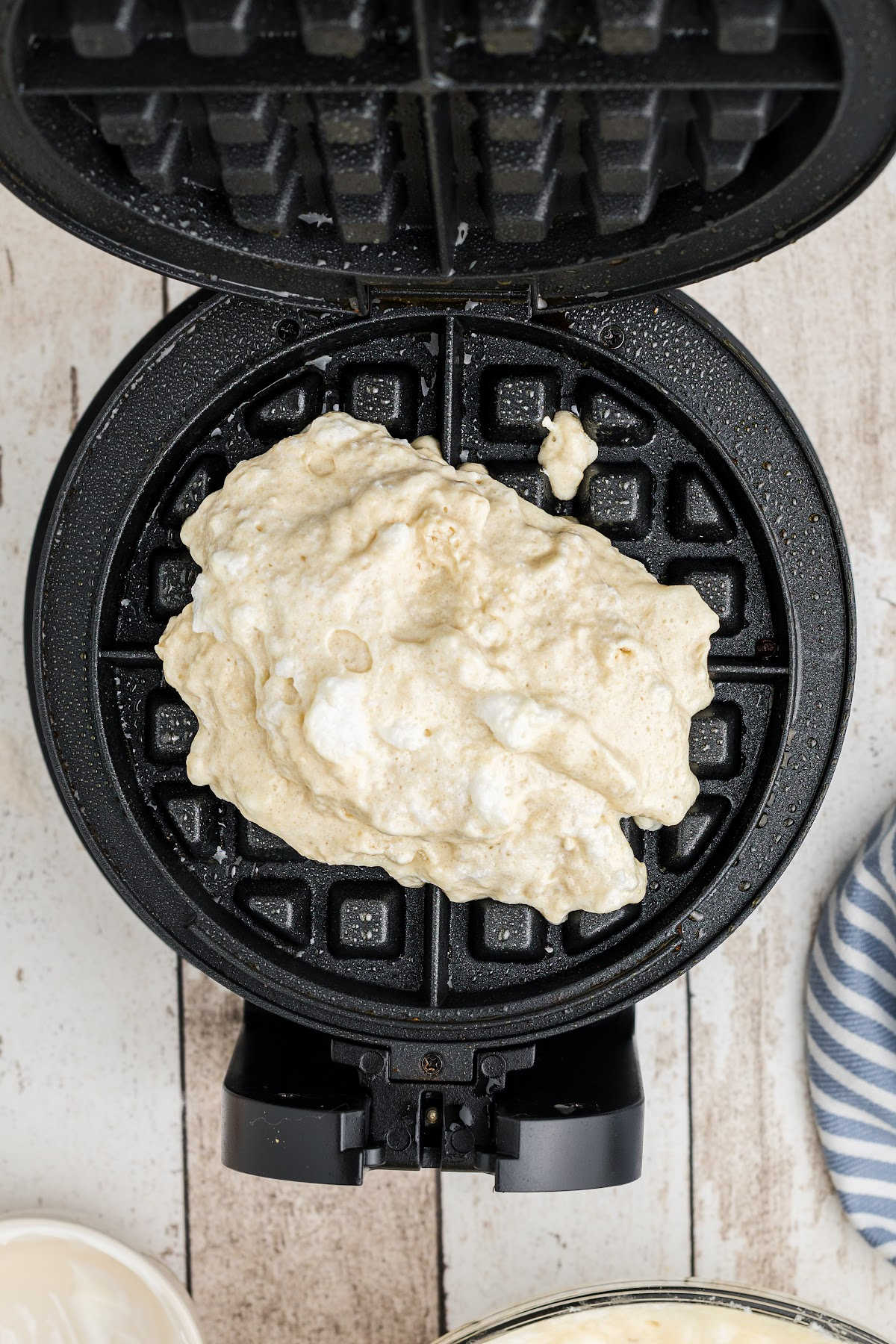 Waffle batter added to a waffle iron.