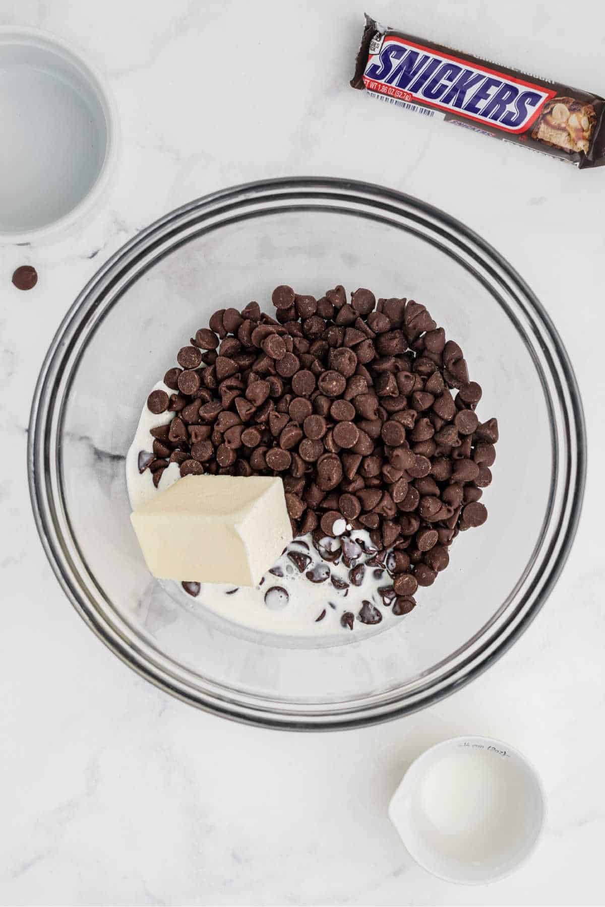 Chocolate chips added to a mixing bowl with butter and sugar, ready to be melted.