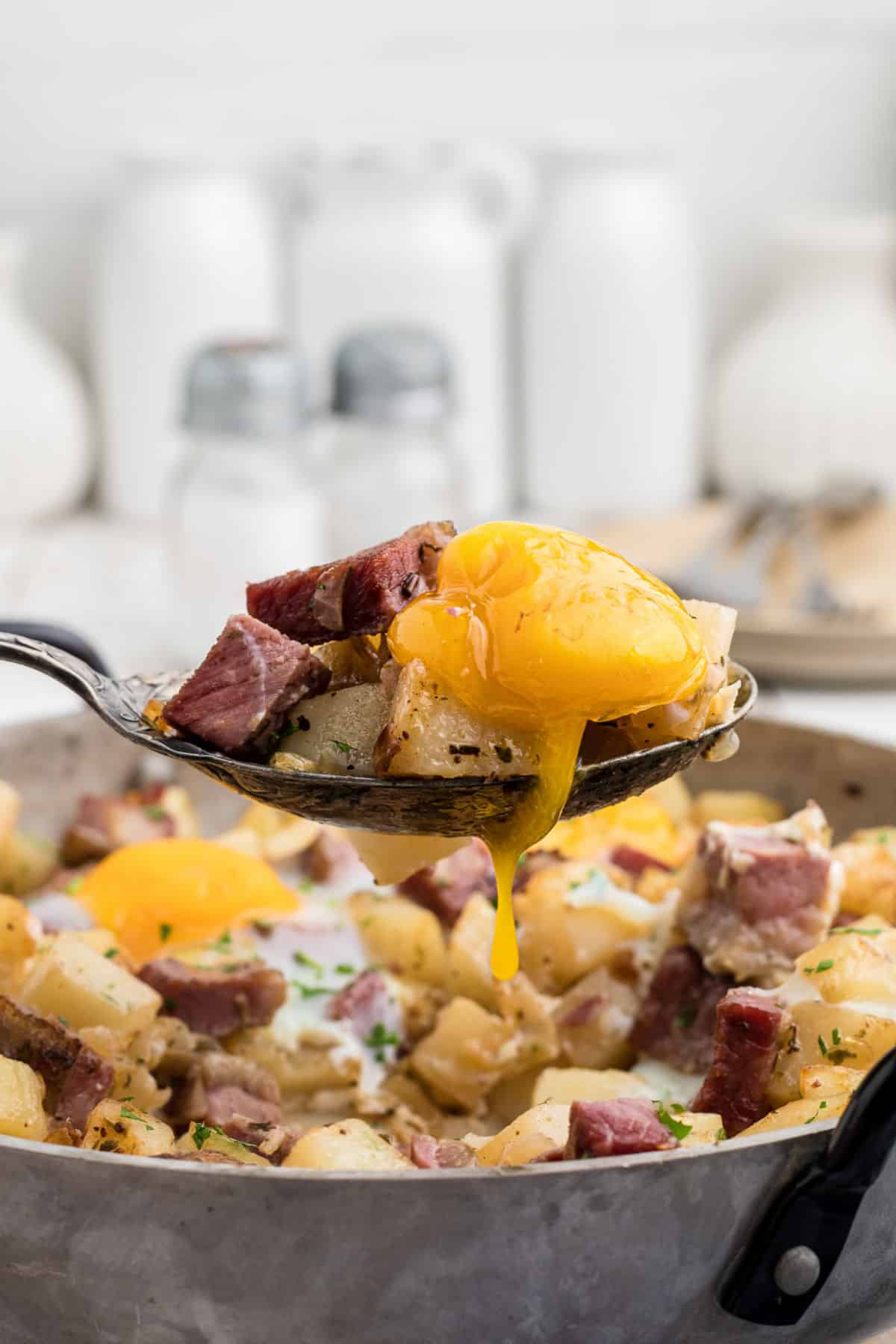 Close up of a spoon digging into a traditional Irish corned beef hash recipe.