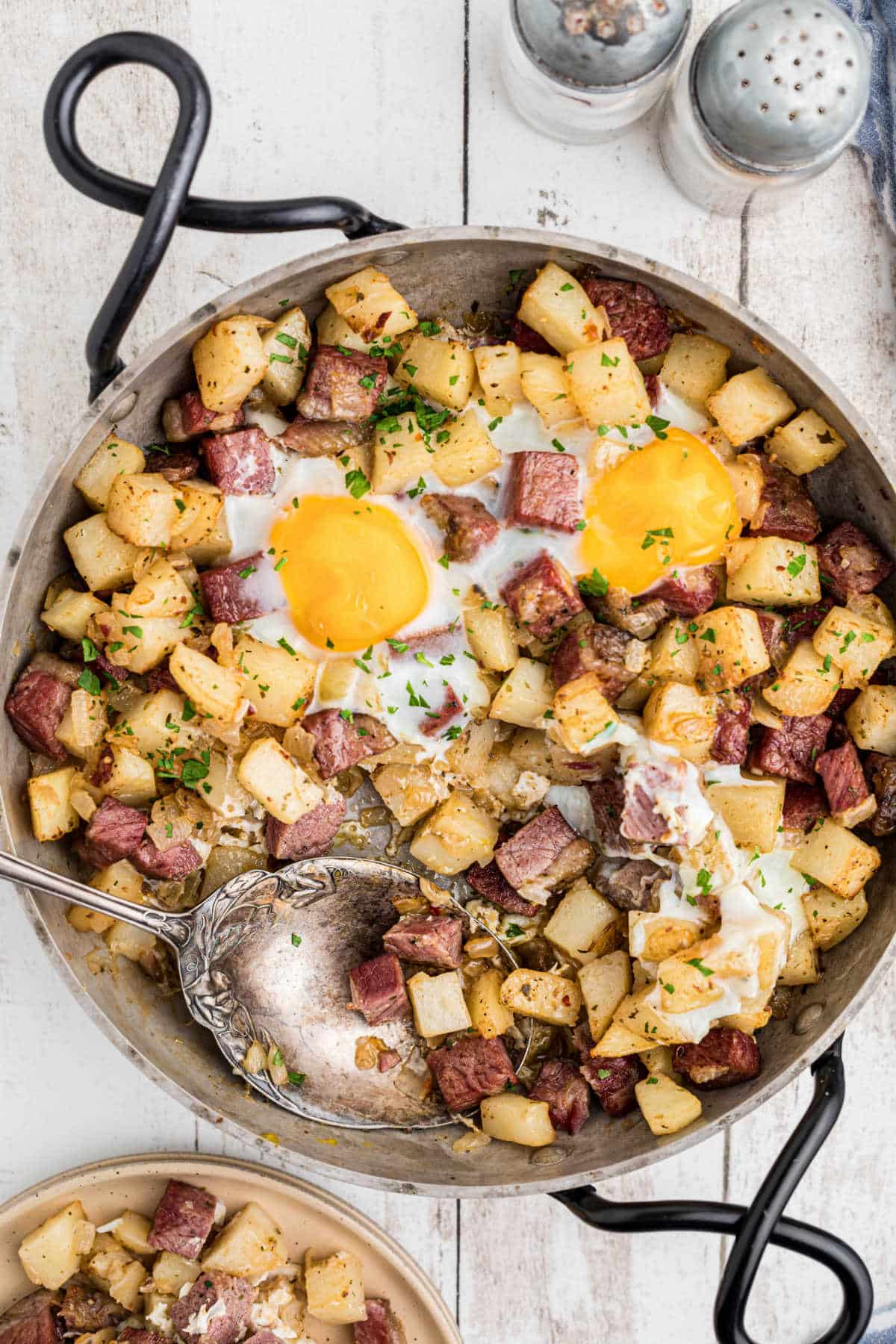 Overhead shot of a skillet with traditional Irish corned beef hash with a spoon digging in.