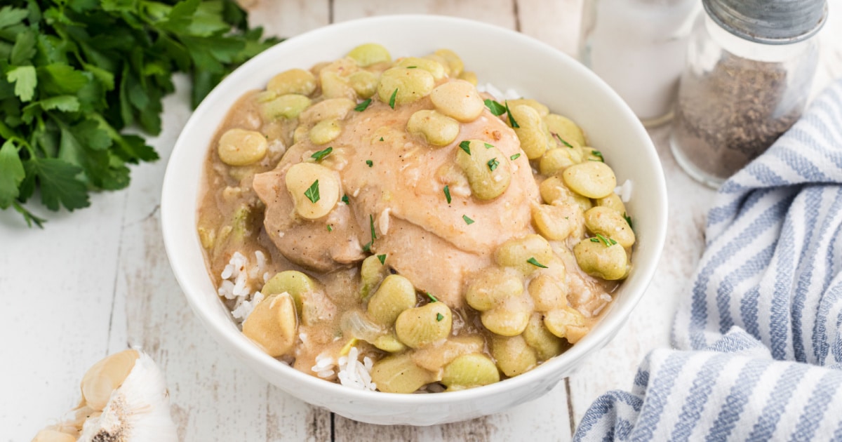 A bowl of chicken and lima beans over rice.