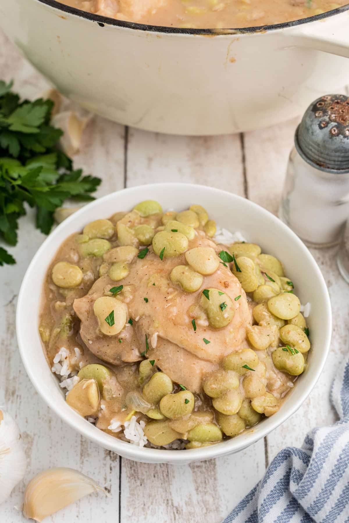 Front view of a bowl of chicken and butter beans on rice.