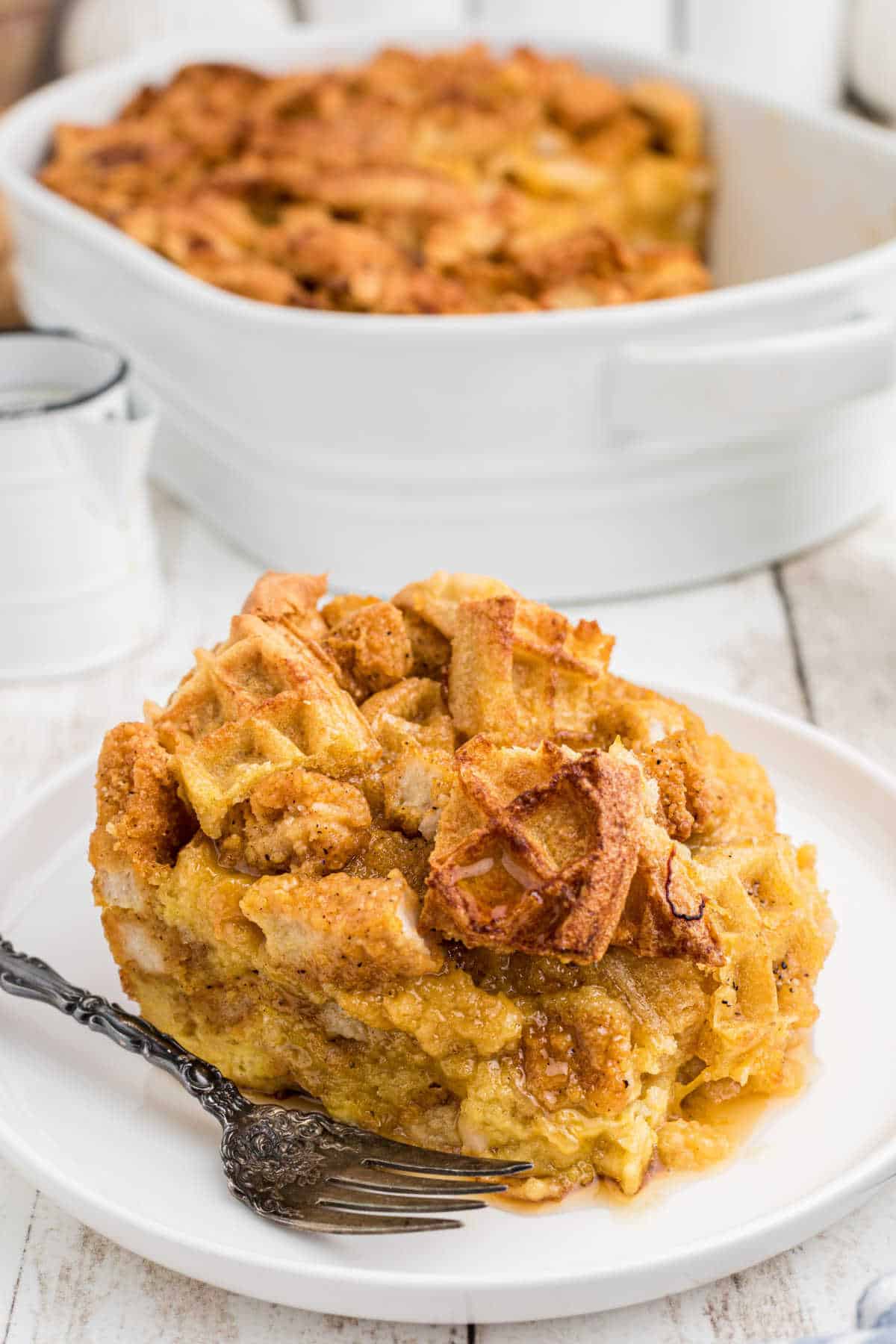 A plate of chicken and waffle casserole recipe with a fork next to it.