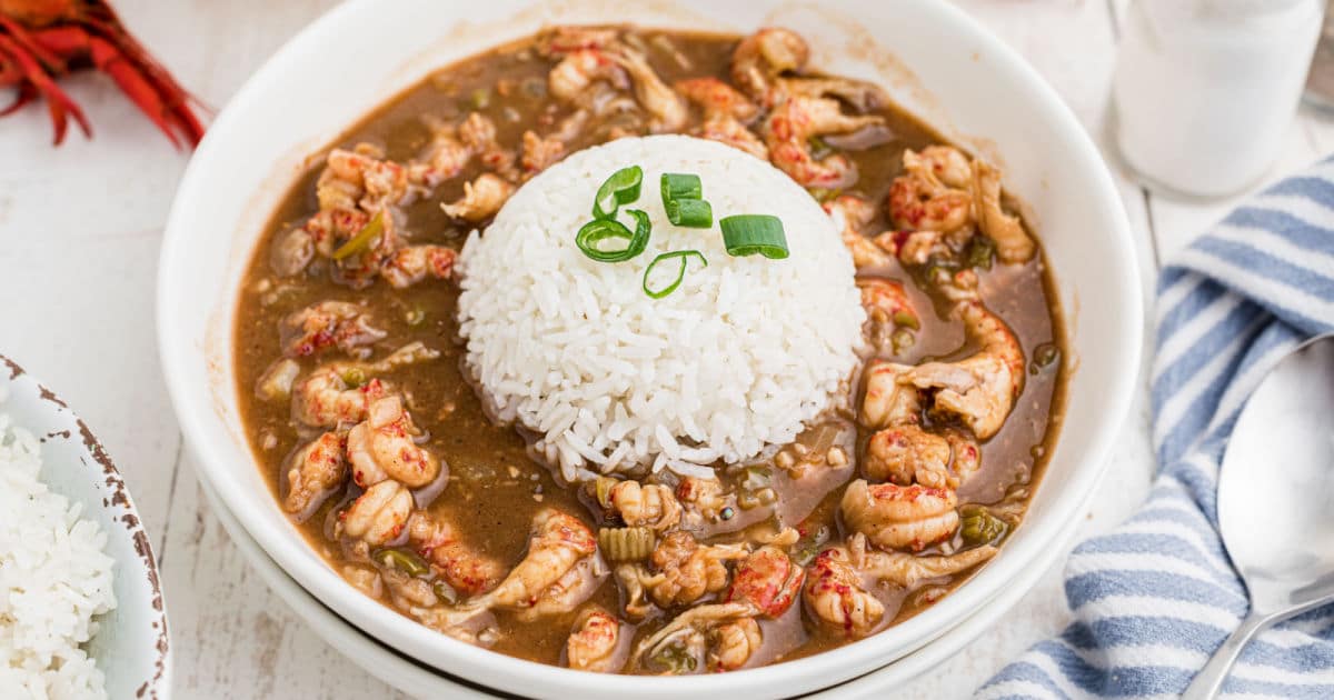 A bowl of crawfish stew with a mound of white rice in the middle.