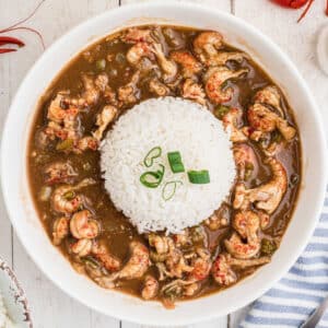 An overhead shot of a bowl of crawfish stew with a heap of white rice in the middle.