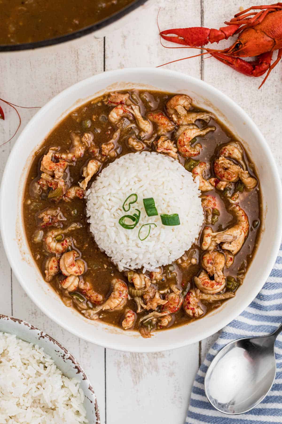 Overhead shot of a bowl of crawfish stew with a heap of white rice in the middle.