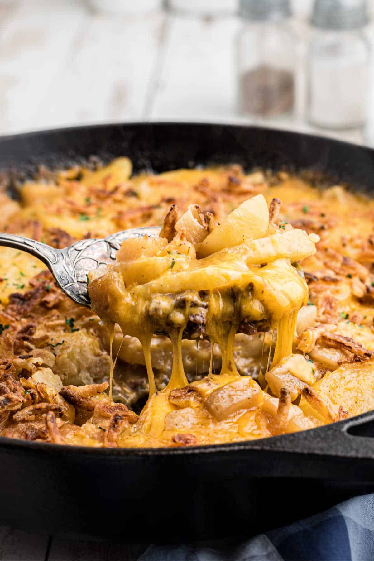 Hobo casserole being scooped out of a skillet.