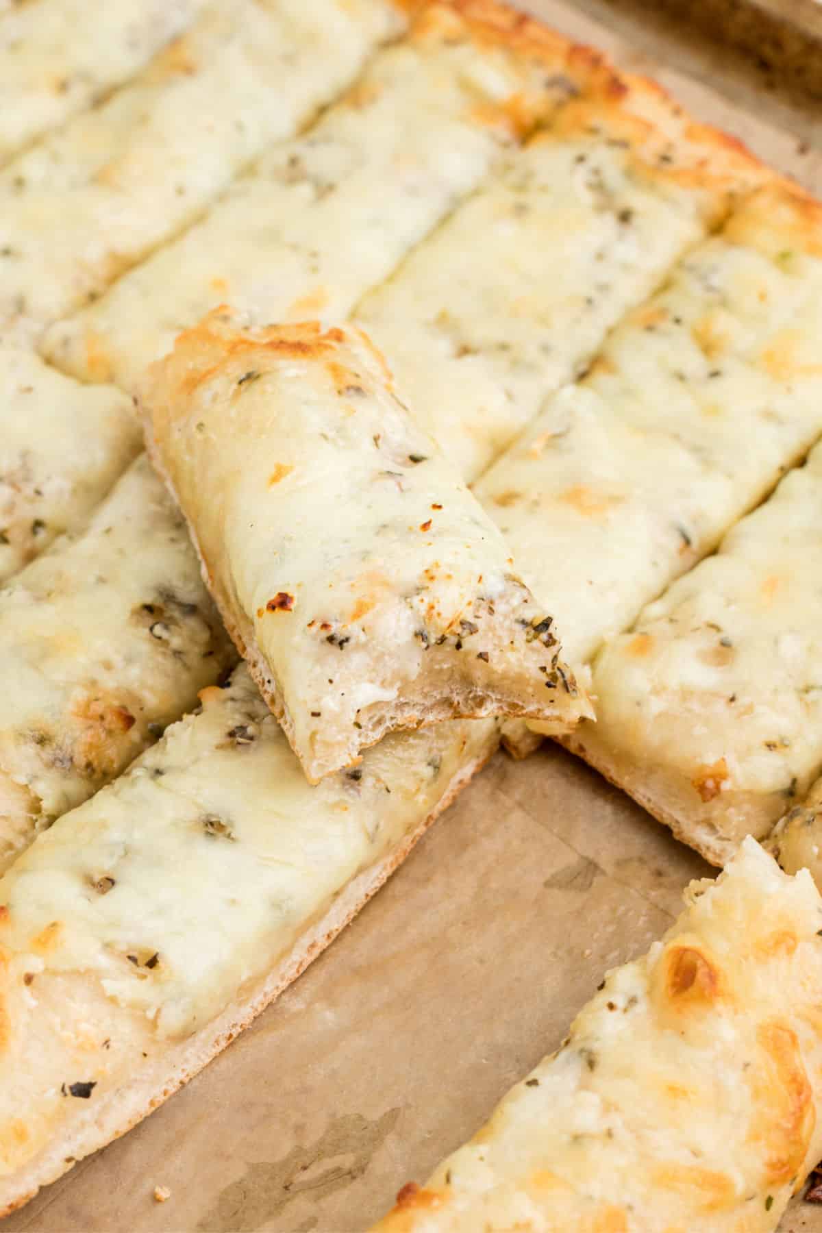 Close up of some Italian Cheese bread with a bite taken out.