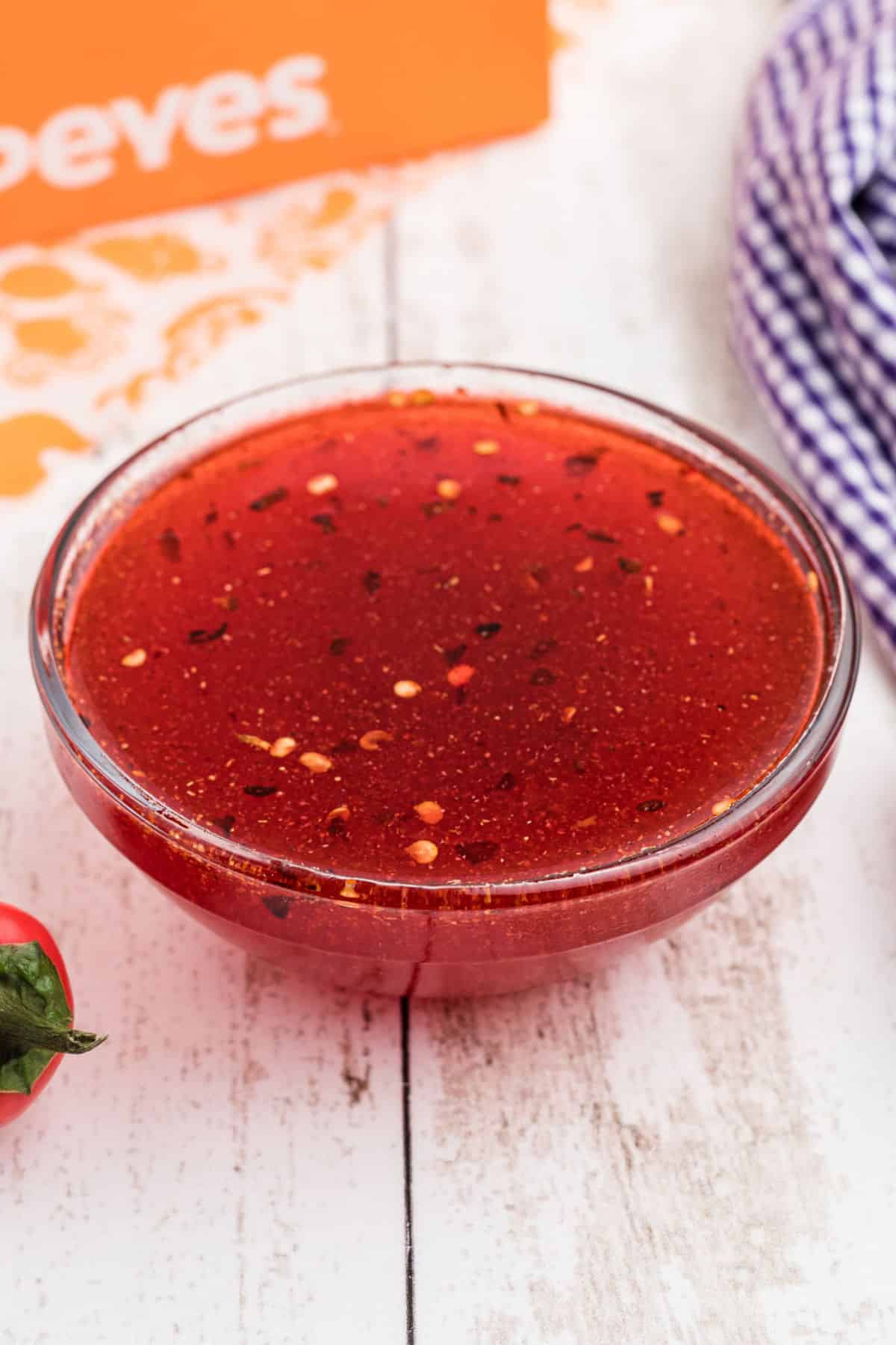 A side shot of a bowl of popeyes sweet heat sauce.