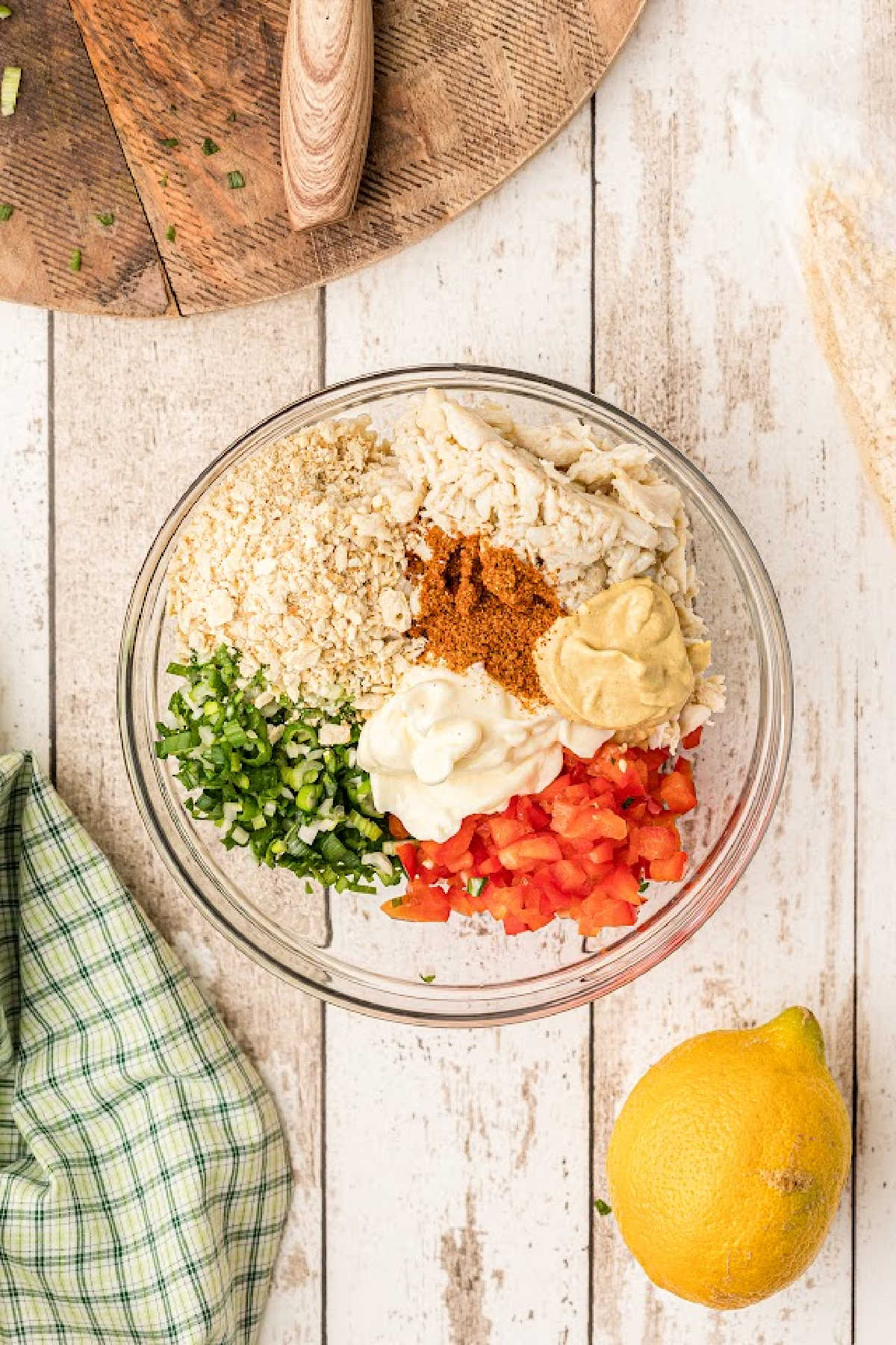 A large mixing bowl full of crab meat, diced veggies and seasonings.