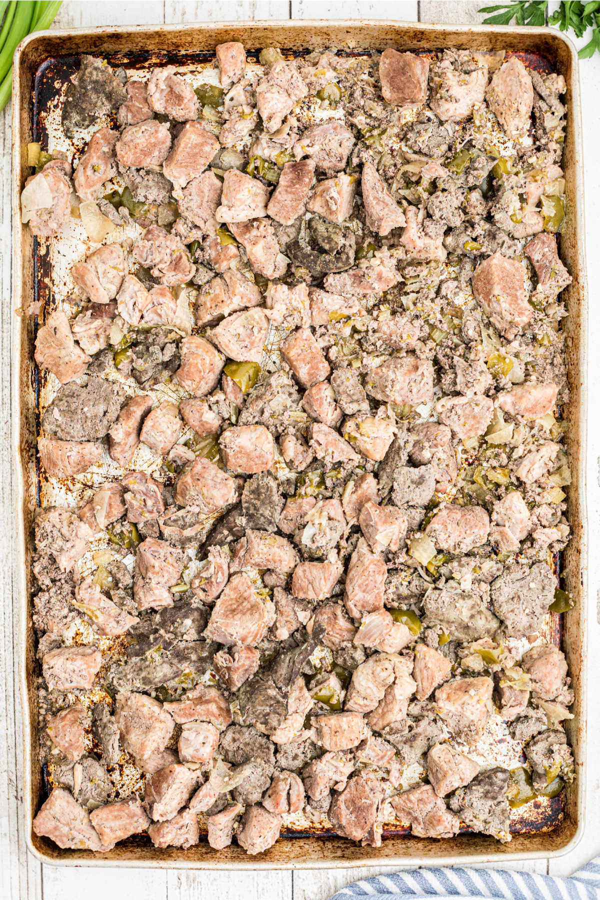 A large baking sheet filled with cooked meat.