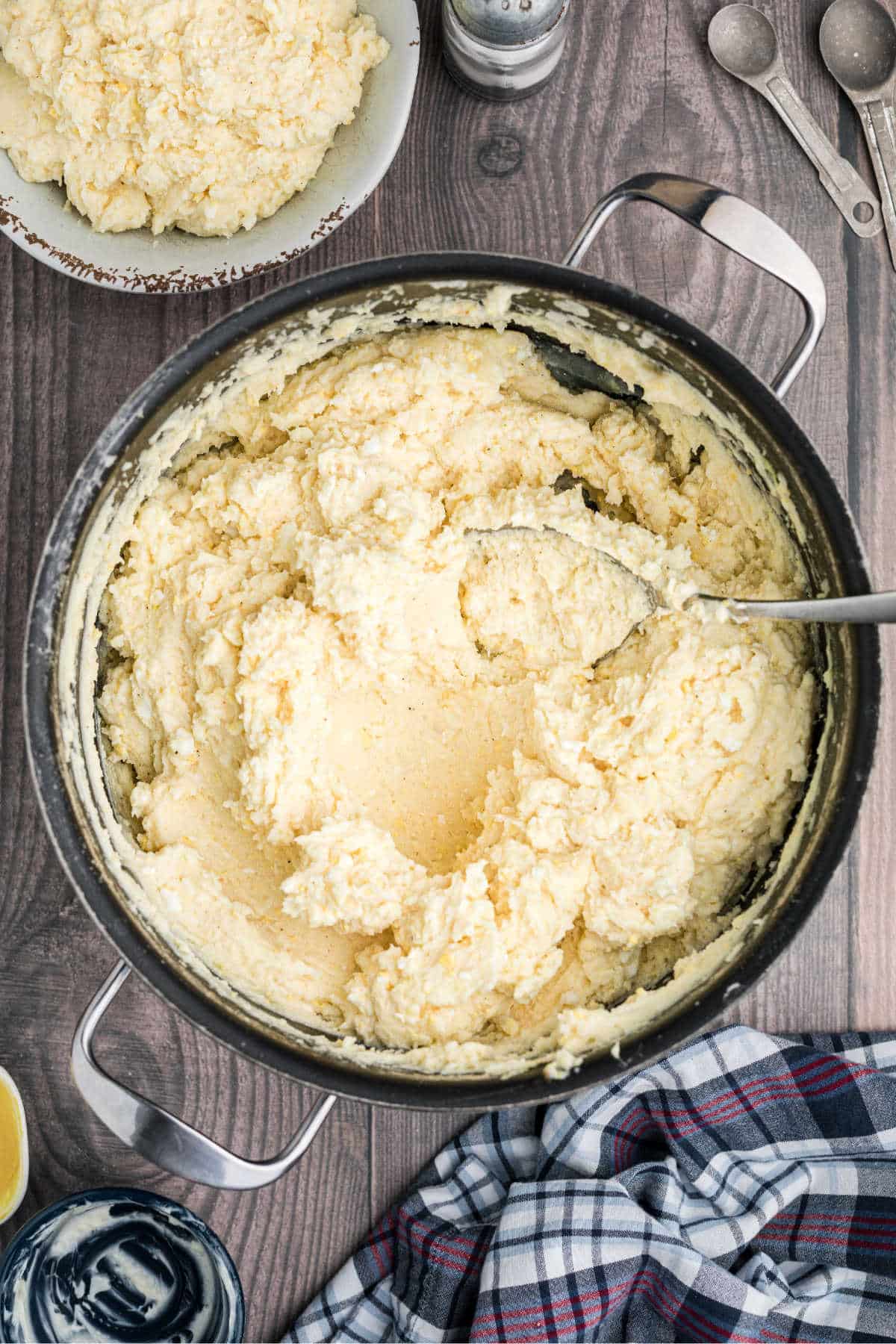 A pot with mashed potatoes and a spoon resting.