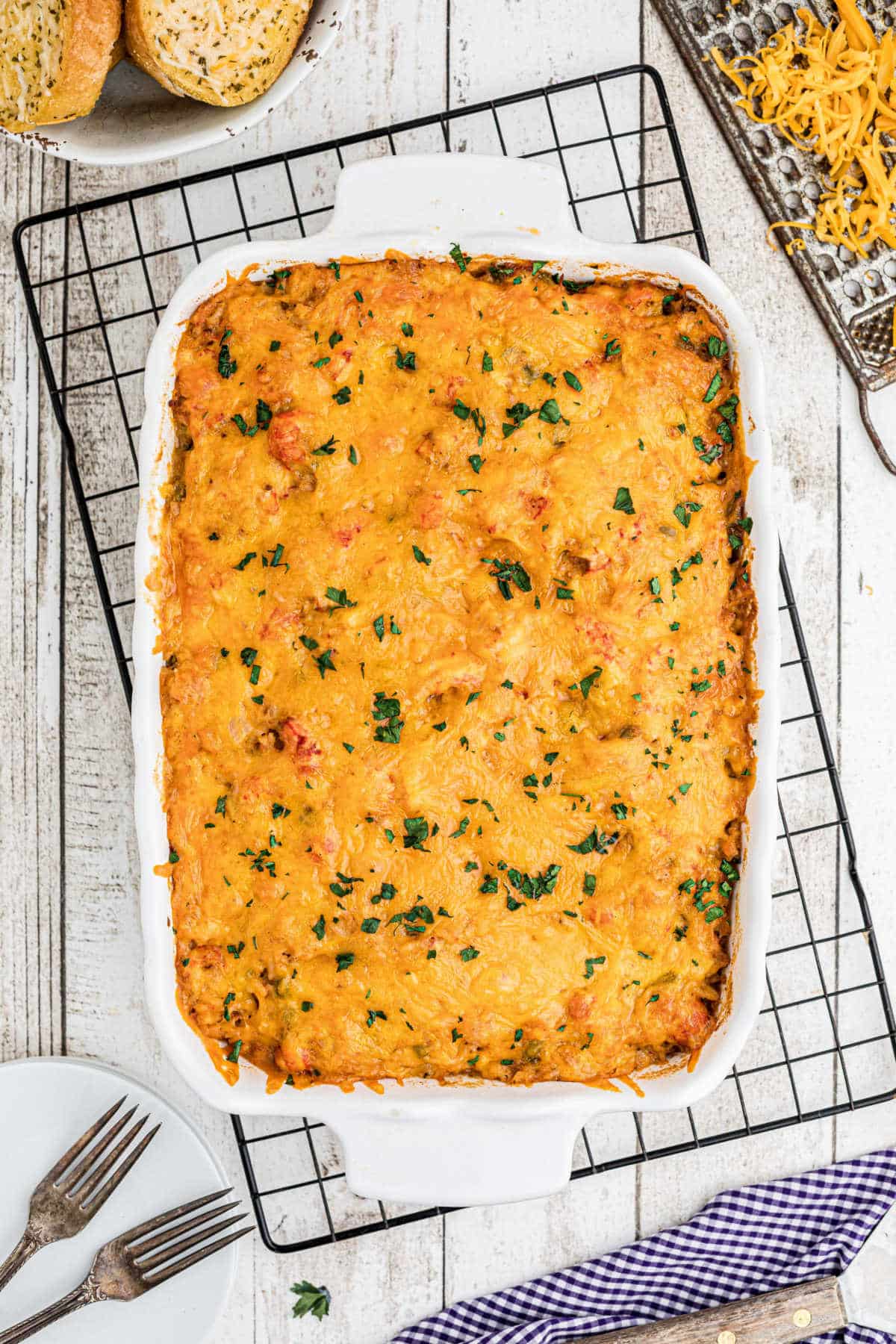 A finished crawfish casserole recipe in a casserole dish on a wire rack.