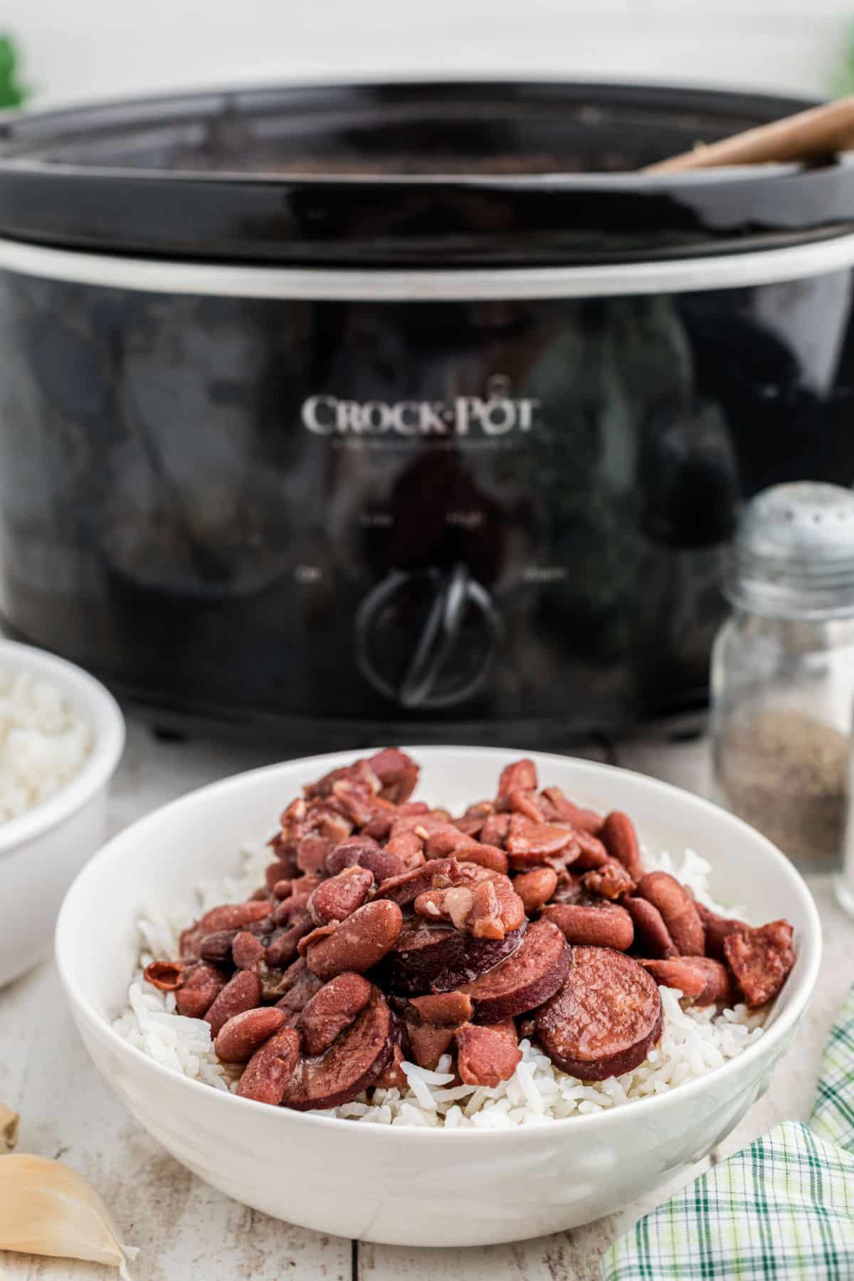 A bowl of Cajun Red Beans and Rice in front of a slow cooker.