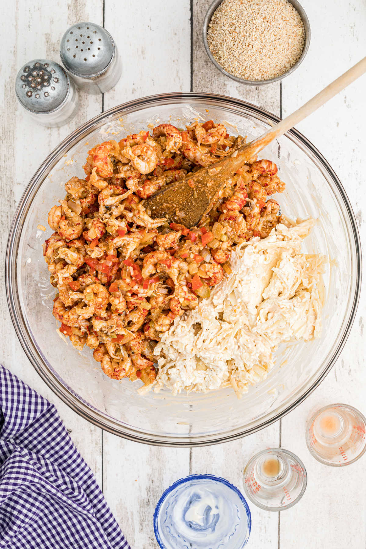 A crawfish mixture added to a mixing bowl with a mixture of cheeses.